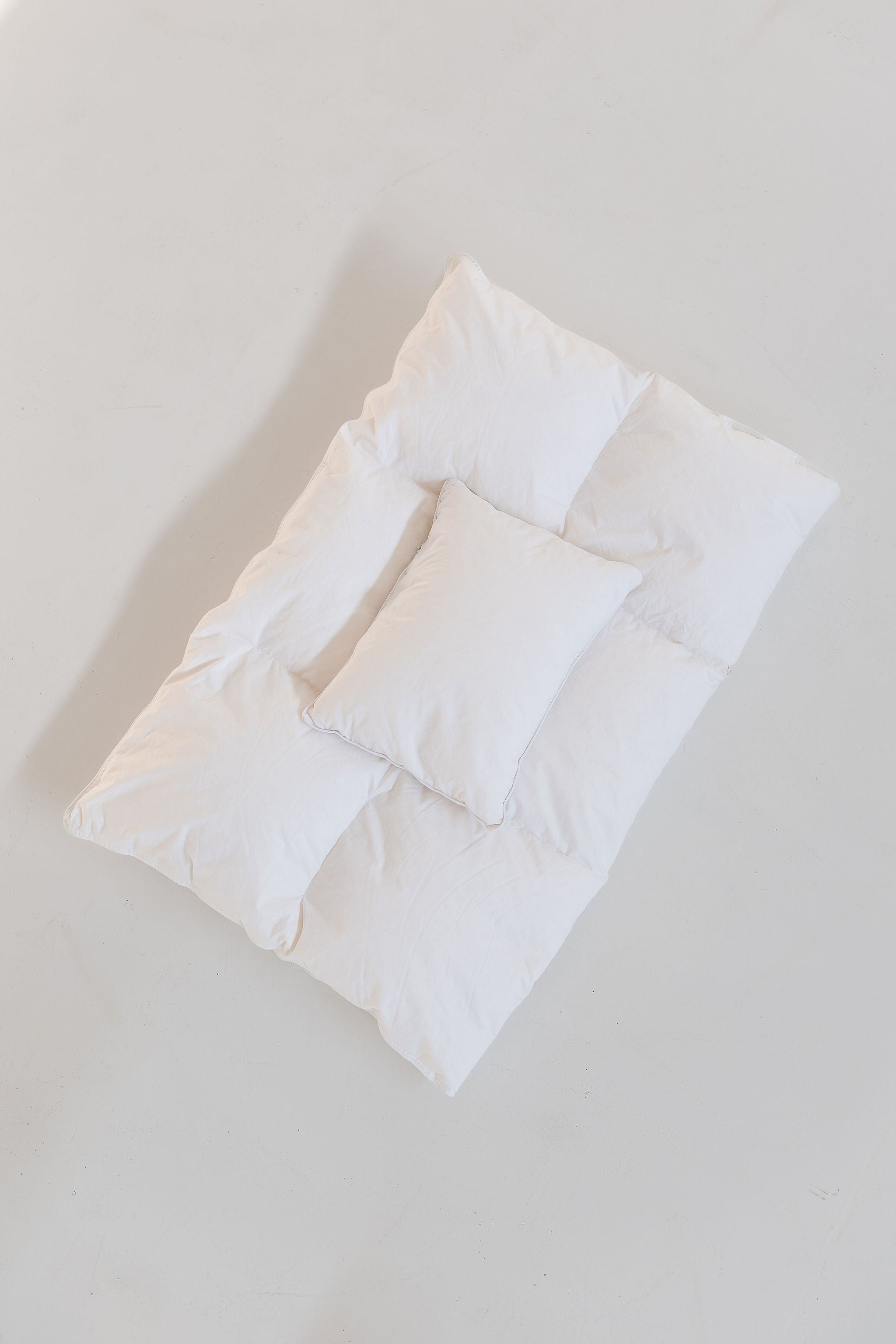 Baby duvet and pillow on a light gray background