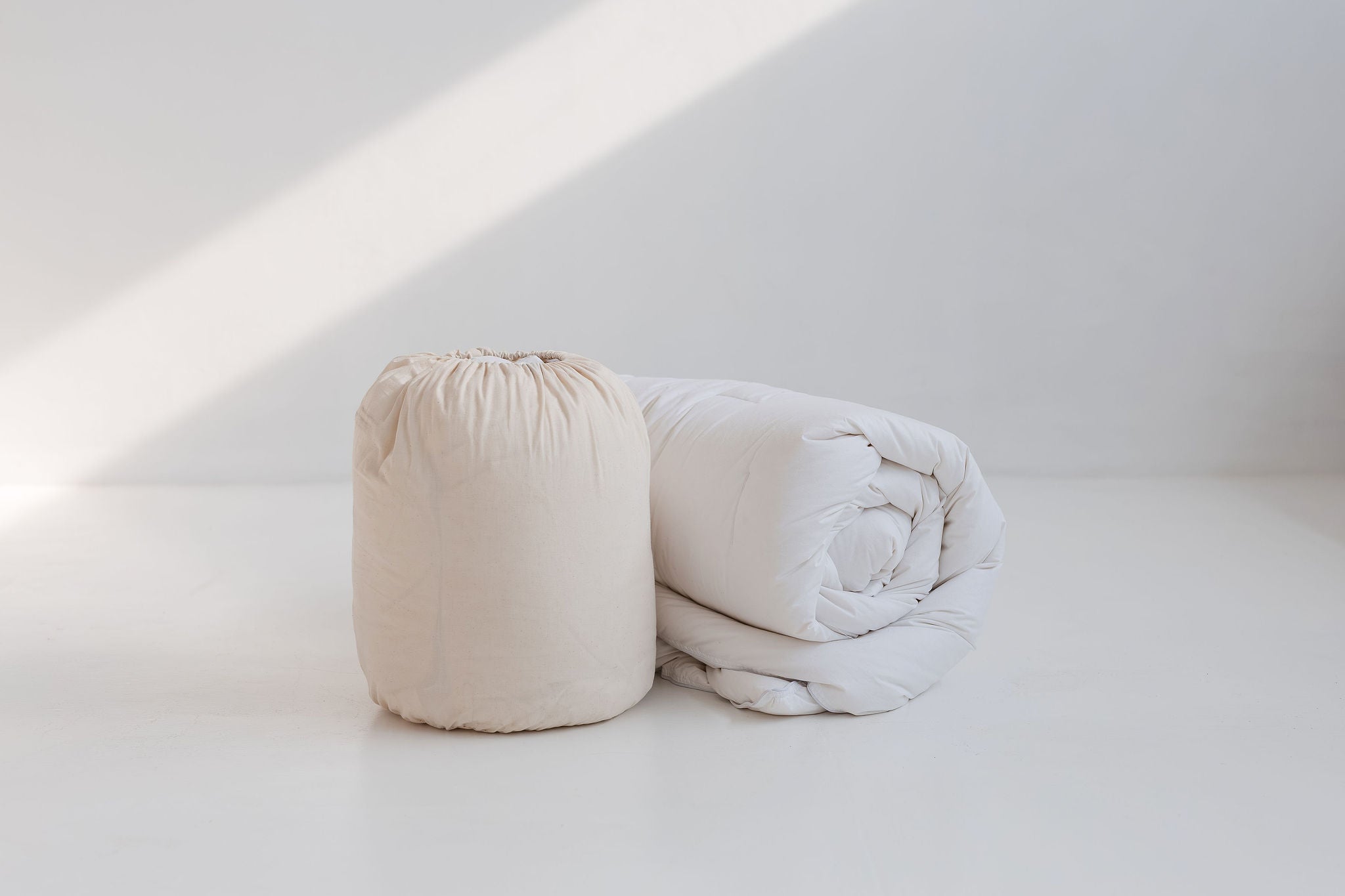 Folded white duvet on a light gray background

Details