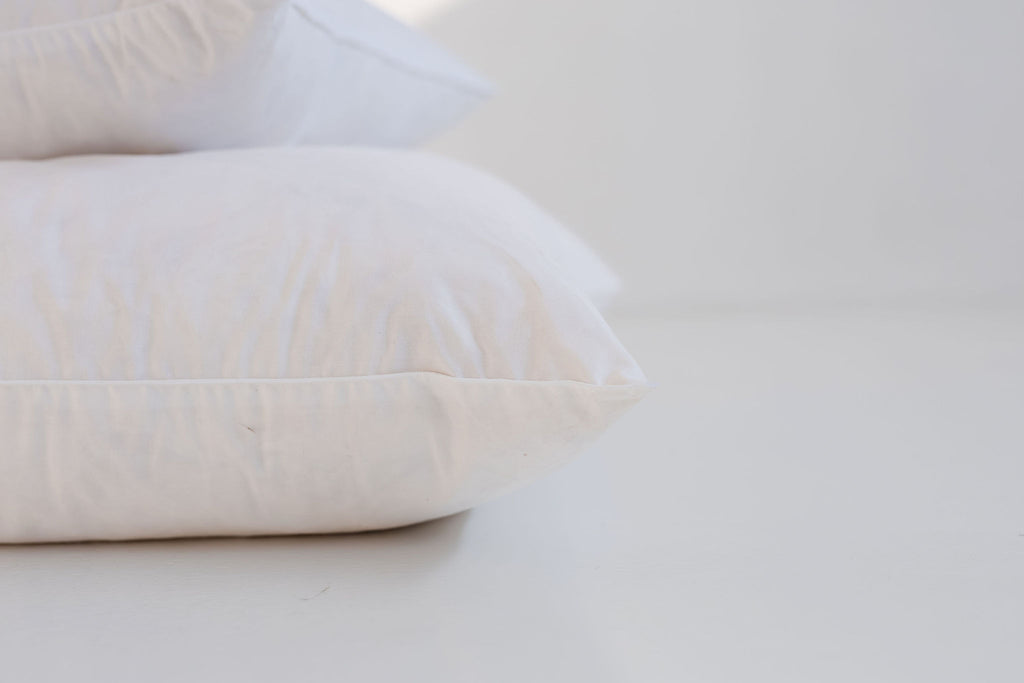 Two white pillows on a light gray surface