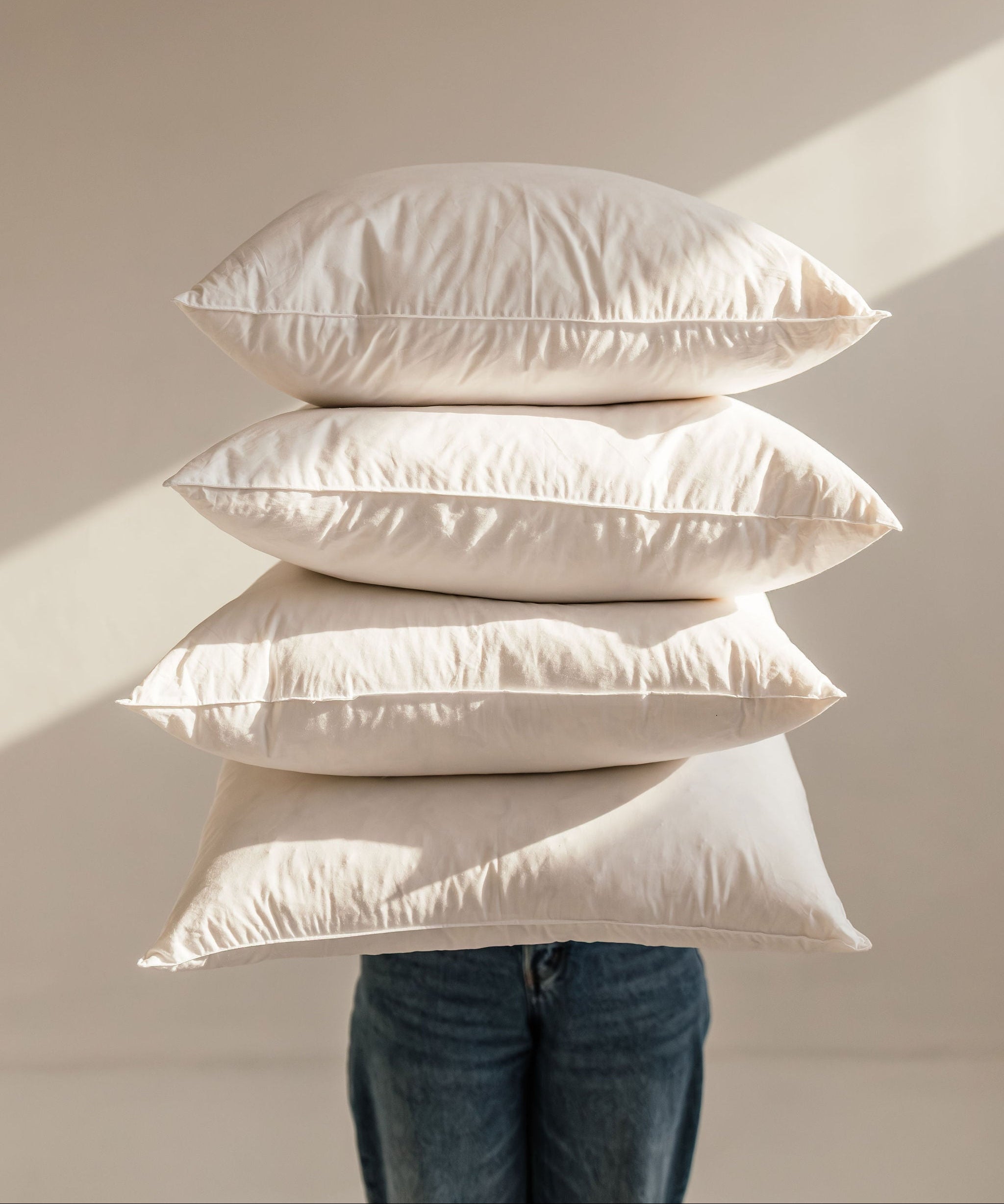 Person holding a stack of pillows